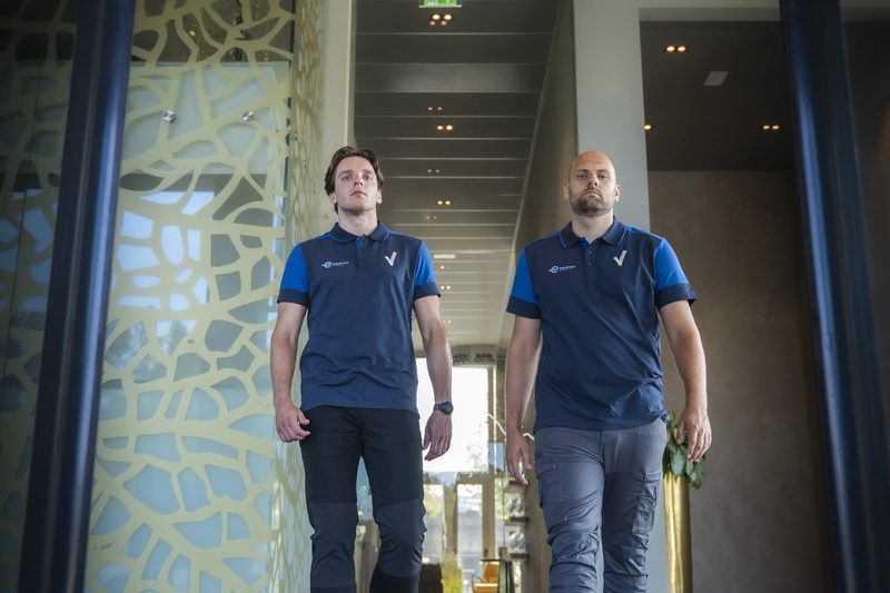 Twee beveiligers van Encrypt Security lopen een gebouw binnen
